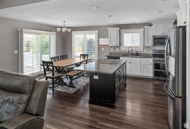 4449 W 5325 S, Hooper, UT 84315 - kitchen featuring appliances with stainless steel finishes, a chandelier, dark wood-style flooring, white cabinetry, and a textured ceiling