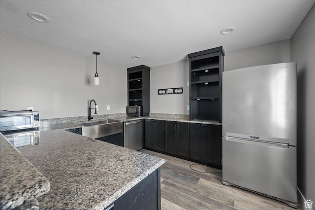 4449 W 5325 S, Hooper, UT 84315 - kitchen with appliances with stainless steel finishes, light wood finished floors, light stone countertops, dark cabinets, and recessed lighting