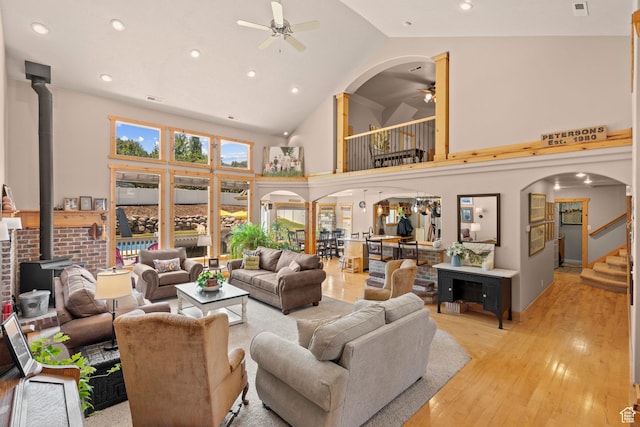 135 W Cove Dr, Elk Ridge, UT 84651 - living area featuring a ceiling fan, a wood stove, stairs, light wood-type flooring, and high vaulted ceiling