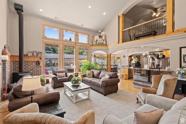 135 W Cove Dr, Elk Ridge, UT 84651 - living area with a wood stove, ceiling fan, high vaulted ceiling, arched walkways, and light wood-style flooring