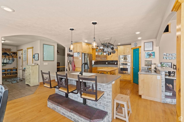 135 W Cove Dr, Elk Ridge, UT 84651 - kitchen with appliances with stainless steel finishes, arched walkways, recessed lighting, light brown cabinets, and light wood-type flooring