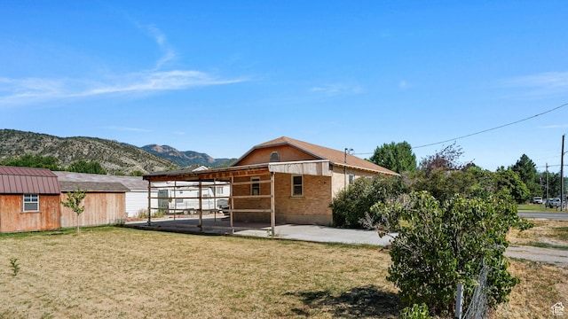 403 E Center, Nephi, UT 84648 - rear view of house with a lawn, a mountain view, and a patio area