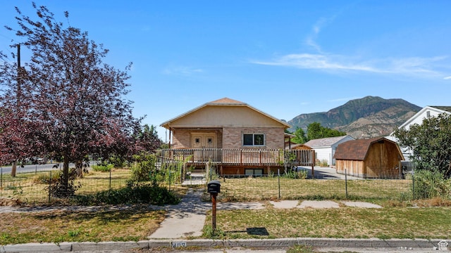 403 E Center, Nephi, UT 84648 - view of front of house with a storage unit, a deck with mountain view, and brick siding