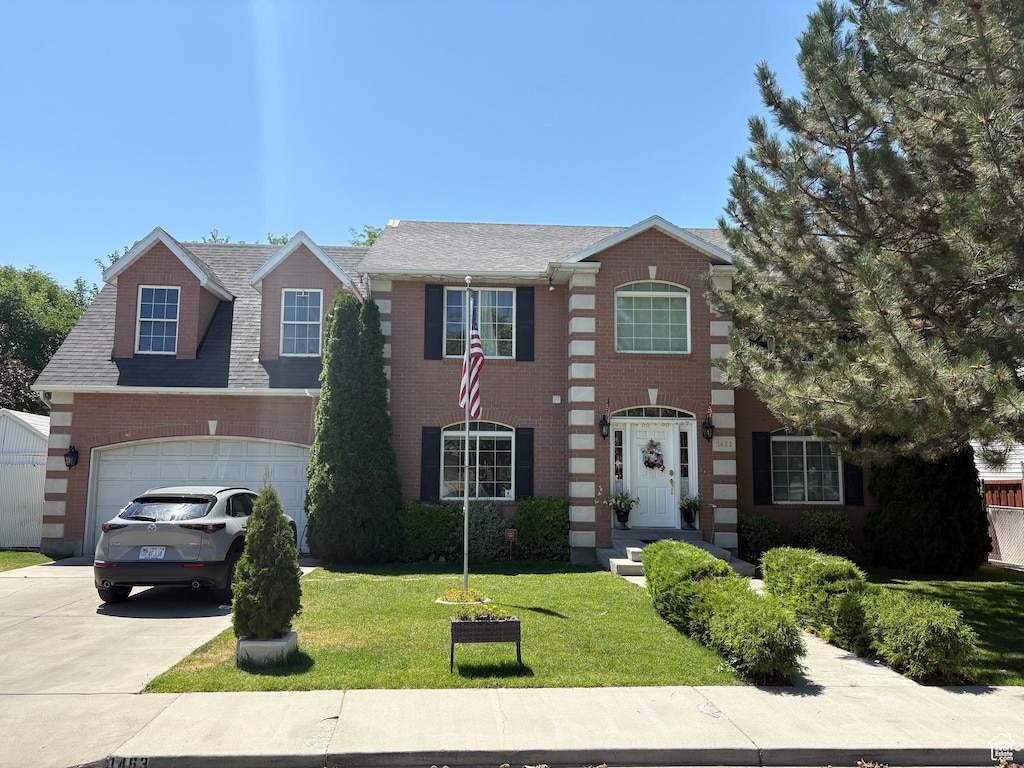 1463 W 730 S, Orem, UT 84058 - view of front of home featuring driveway, brick siding, a front lawn, an attached garage, and a shingled roof
