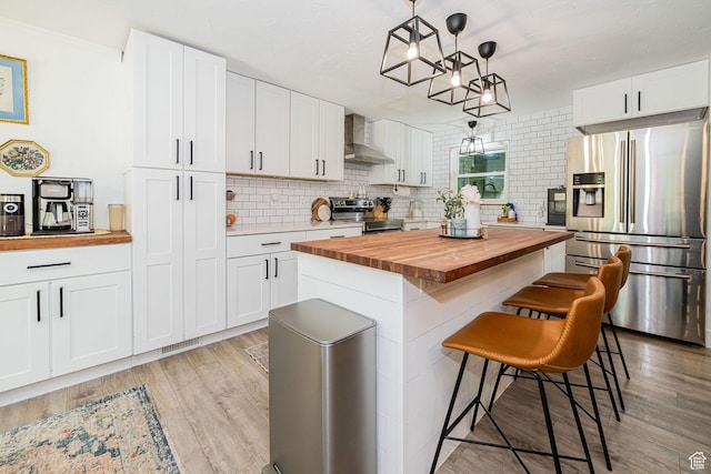 2127 E 5950 N, Liberty, UT 84310 - kitchen featuring wood counters, stainless steel appliances, wall chimney exhaust hood, white cabinets, and a kitchen breakfast bar