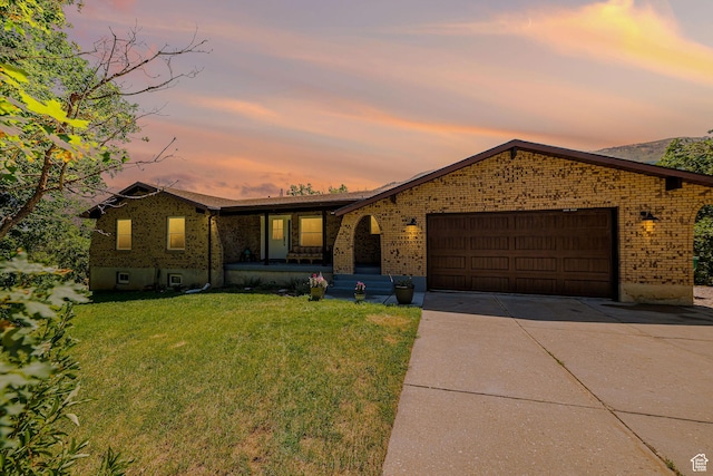 2127 E 5950 N, Liberty, UT 84310 - view of front of property featuring brick siding, a front yard, concrete driveway, a garage, and covered porch