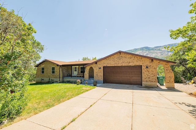 2127 E 5950 N, Liberty, UT 84310 - ranch-style home featuring brick siding, a front lawn, an attached garage, concrete driveway, and a mountain view