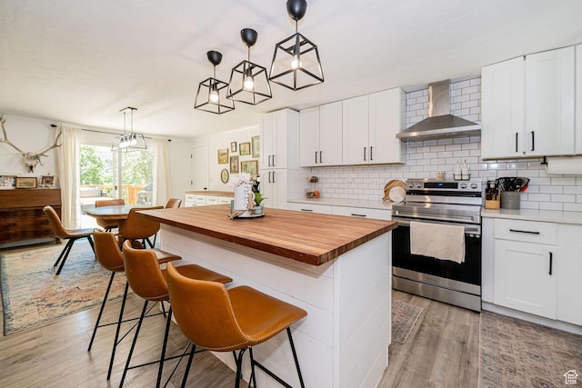 2127 E 5950 N, Liberty, UT 84310 - kitchen featuring wall chimney exhaust hood, stainless steel range with electric cooktop, wood counters, and light wood-style floors
