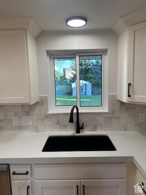 1456 E 5935 S, Murray, UT 84121 - kitchen featuring white cabinetry, light countertops, decorative backsplash, and stainless steel dishwasher