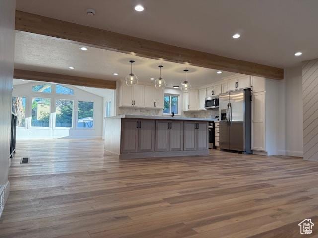 1456 E 5935 S, Murray, UT 84121 - kitchen featuring appliances with stainless steel finishes, open floor plan, beam ceiling, light wood finished floors, and white cabinets