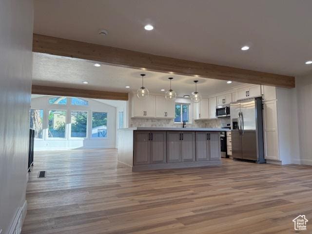 1456 E 5935 S, Murray, UT 84121 - kitchen featuring appliances with stainless steel finishes, beamed ceiling, light wood-style floors, open floor plan, and white cabinets