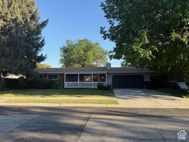 1456 E 5935 S, Murray, UT 84121 - ranch-style house featuring concrete driveway, an attached garage, a front lawn, and a porch