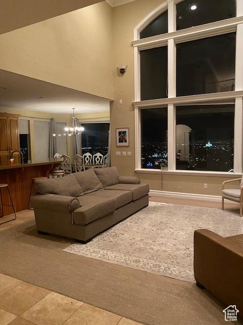9061 N Canyon Dr, Cedar Hills, UT 84062 - carpeted living area featuring a chandelier, a high ceiling, and tile patterned flooring
