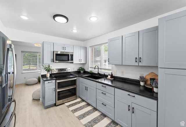 25 E 1860 N, Tooele, UT 84074 - kitchen featuring appliances with stainless steel finishes, dark countertops, light wood-style floors, recessed lighting, and healthy amount of natural light