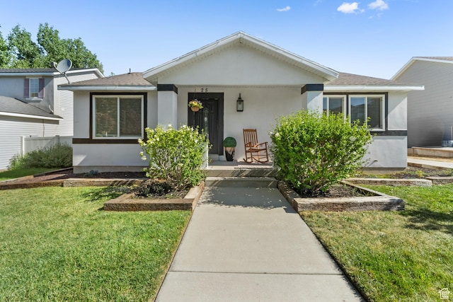 25 E 1860 N, Tooele, UT 84074 - view of front of house featuring covered porch, stucco siding, and a front yard