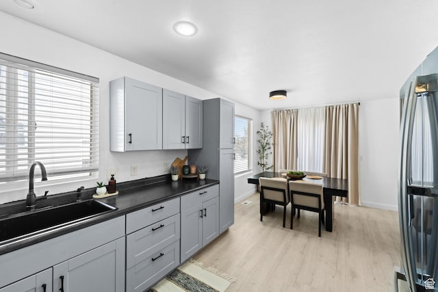 25 E 1860 N, Tooele, UT 84074 - kitchen featuring stainless steel fridge, dark countertops, light wood-type flooring, and gray cabinets