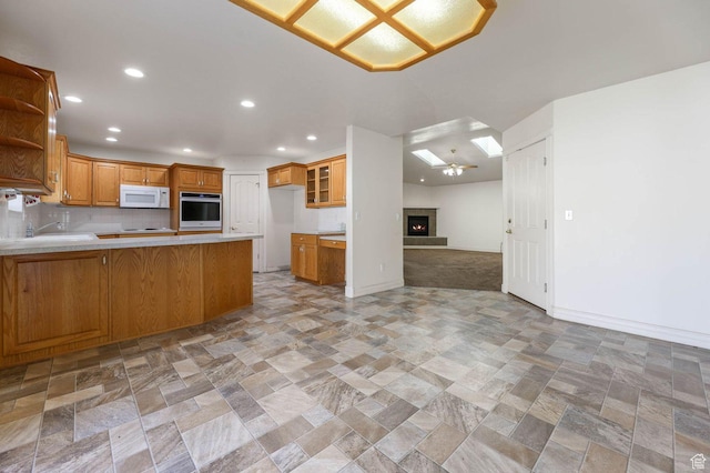 2474 N Dorchester Ave, Harrisville, UT 84414 - kitchen featuring white microwave, stainless steel oven, open floor plan, a peninsula, and light stone finish floors