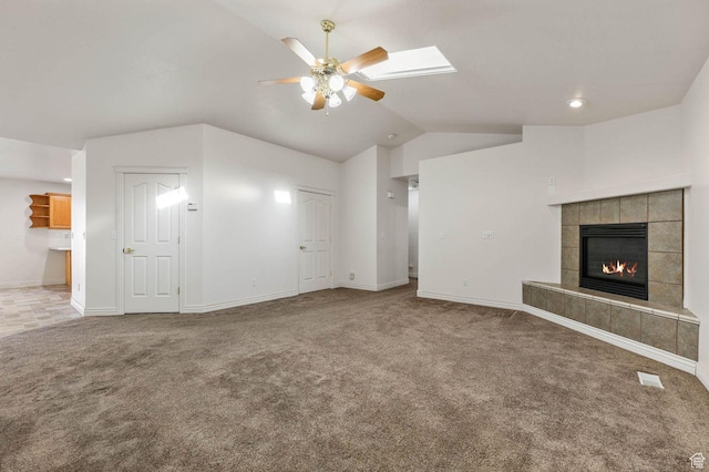 2474 N Dorchester Ave, Harrisville, UT 84414 - unfurnished living room with ceiling fan, carpet, lofted ceiling, a tile fireplace, and a skylight