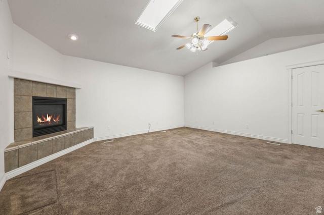 2474 N Dorchester Ave, Harrisville, UT 84414 - unfurnished living room with lofted ceiling, carpet floors, ceiling fan, a tile fireplace, and a skylight
