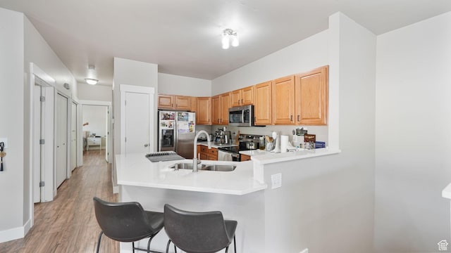 8457 S Ivy Springs Ln W, West Jordan, UT 84081 - kitchen with appliances with stainless steel finishes, a peninsula, light countertops, and a kitchen bar