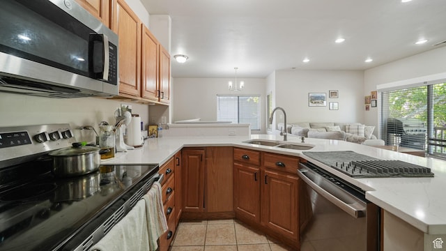 8457 S Ivy Springs Ln W, West Jordan, UT 84081 - kitchen with appliances with stainless steel finishes, light tile patterned floors, a chandelier, a peninsula, and light stone countertops