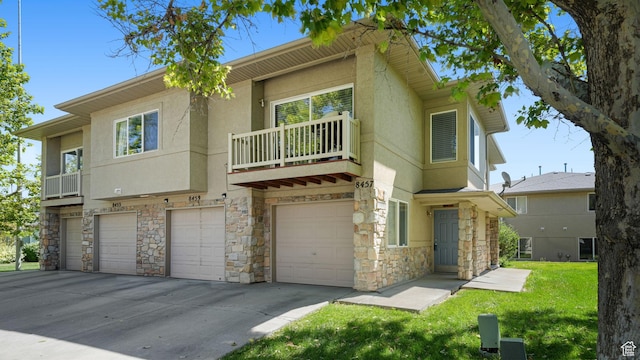 8457 S Ivy Springs Ln W, West Jordan, UT 84081 - view of front of home with stone siding, a garage, a balcony, stucco siding, and driveway