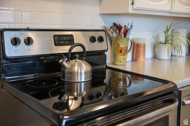 70 N 1100 W, Vernal, UT 84078 - kitchen view of stainless steel electric range oven, backsplash, and white cabinets