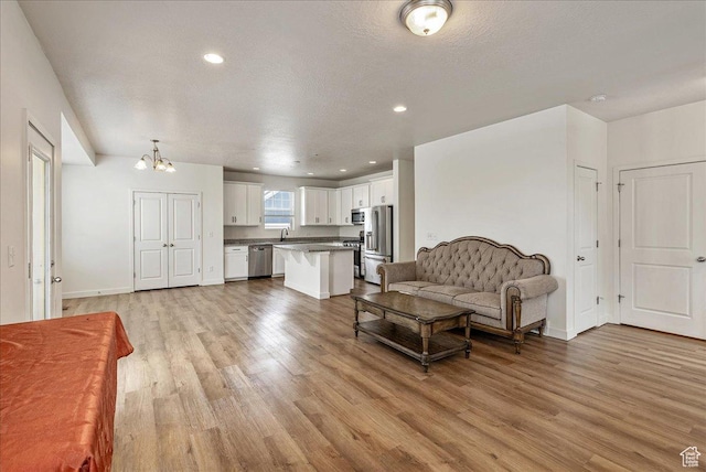 5239 W Mellow Way S, Jordan, UT 84009 - living room with a chandelier, light wood-style flooring, and recessed lighting