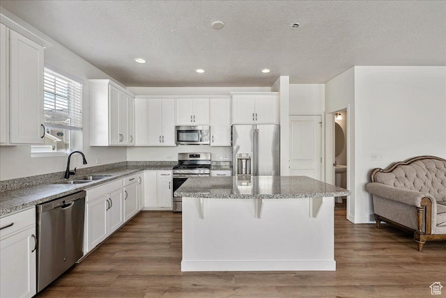 5239 W Mellow Way S, Jordan, UT 84009 - kitchen with stainless steel appliances, a kitchen island, white cabinetry, recessed lighting, and a textured ceiling