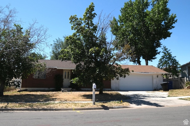 4217 W Twilight Dr S, Salt Lake City, UT 84118 - view of front of house with driveway, a garage, and brick siding