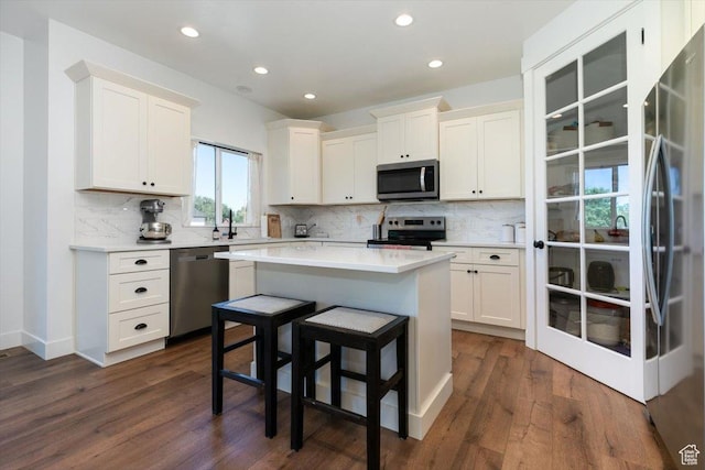 165 N 300 W, Preston, ID 83263 - kitchen featuring appliances with stainless steel finishes, white cabinetry, decorative backsplash, dark wood-style floors, and recessed lighting