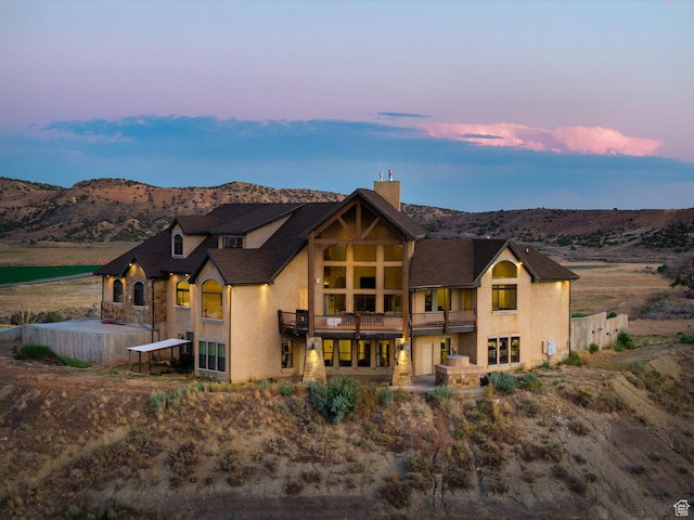 2849 W 1800 S, Vernal, UT 84078 - view of front of home featuring a balcony, stucco siding, a mountain view, and a chimney