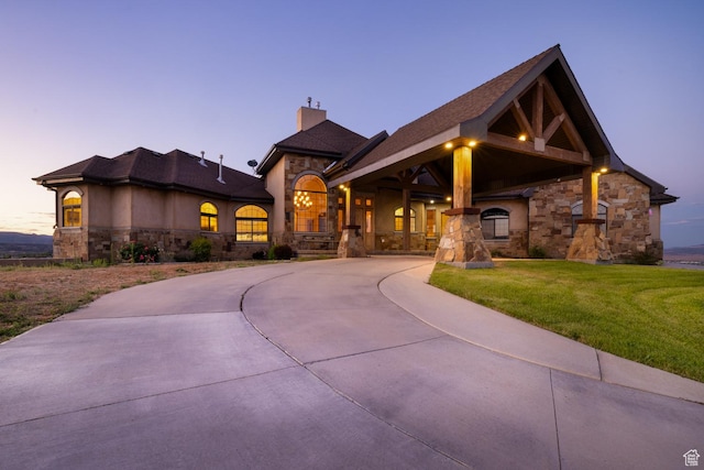 2849 W 1800 S, Vernal, UT 84078 - view of front facade with stone siding, a chimney, a yard, and curved driveway