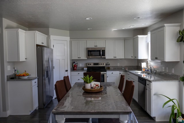 122 N 1325 W, Springville, UT 84663 - kitchen with stainless steel appliances, dark wood finished floors, white cabinetry, a textured ceiling, and light stone counters