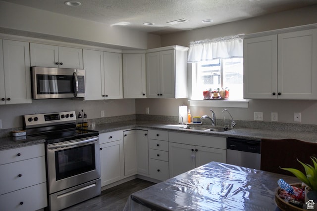 122 N 1325 W, Springville, UT 84663 - kitchen with appliances with stainless steel finishes, white cabinets, dark wood-type flooring, and a textured ceiling