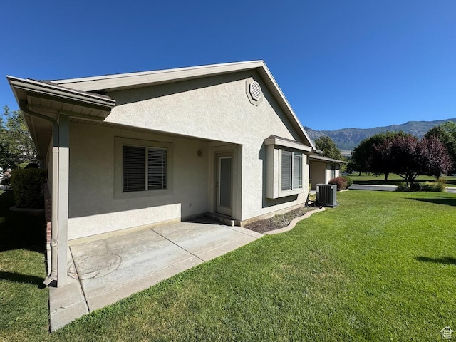 94 Hillsborough Dr, Pleasant View, UT 84414 - back of property featuring stucco siding, a mountain view, a lawn, and a patio area
