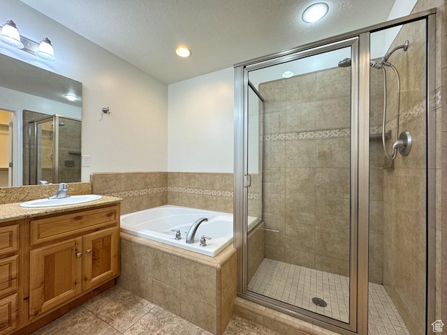 94 Hillsborough Dr, Pleasant View, UT 84414 - full bathroom featuring a shower stall, vanity, a garden tub, tile patterned floors, and a textured ceiling