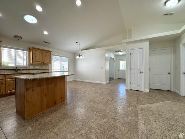 94 Hillsborough Dr, Pleasant View, UT 84414 - kitchen with a center island, vaulted ceiling, light tile patterned floors, light stone counters, and decorative light fixtures
