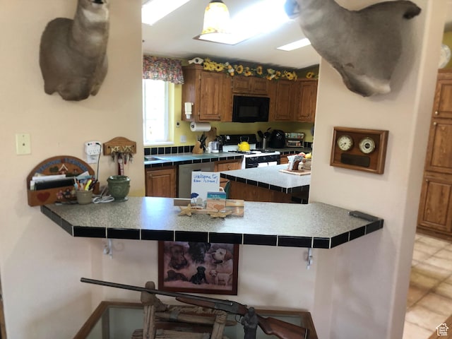 15700 N 7100 E, Spring City, UT 84662 - kitchen featuring gas range gas stove, black microwave, a kitchen breakfast bar, a peninsula, and tile counters