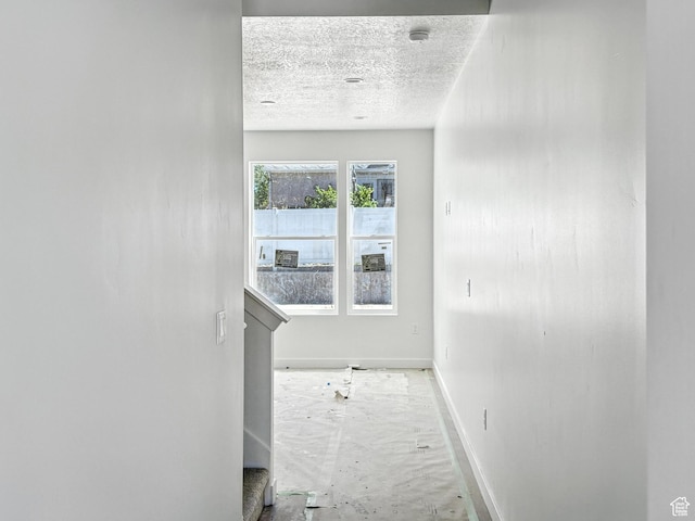8239 W Joshua Tree Ln, Magna, UT 84044 - corridor featuring baseboards and a textured ceiling