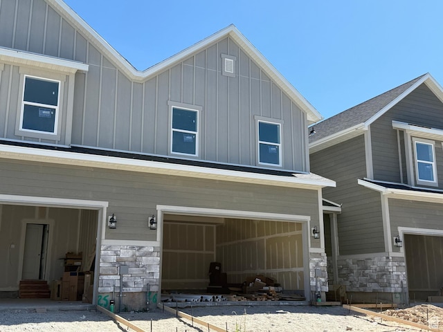 8239 W Joshua Tree Ln, Magna, UT 84044 - view of front facade featuring stone siding, a garage, and board and batten siding
