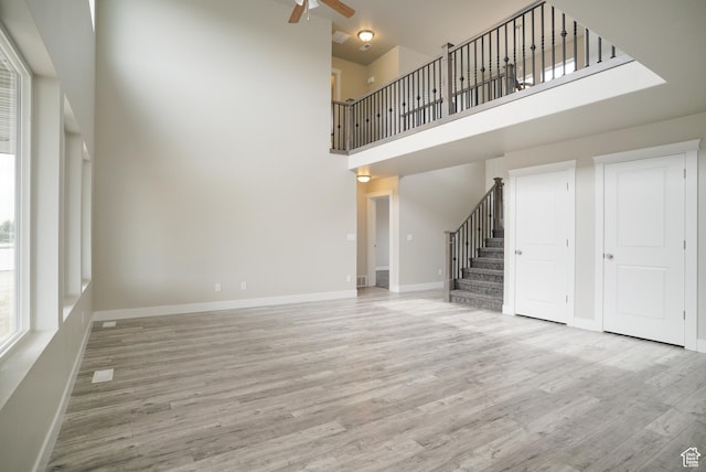 3045 S 2275 W, West Haven, UT 84401 - unfurnished living room with a high ceiling, stairs, a ceiling fan, and wood finished floors