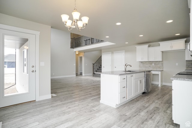 3045 S 2275 W, West Haven, UT 84401 - kitchen featuring backsplash, light wood finished floors, white cabinets, a kitchen island with sink, and recessed lighting