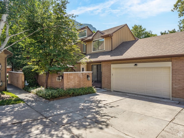 3818 N Little Rock Ct E, Provo, UT 84604 - view of front facade with board and batten siding, driveway, brick siding, and a garage