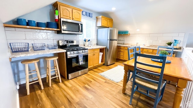 325 S 100 W, Garden City, UT 84028 - kitchen with stainless steel appliances, tasteful backsplash, light wood-type flooring, open shelves, and vaulted ceiling