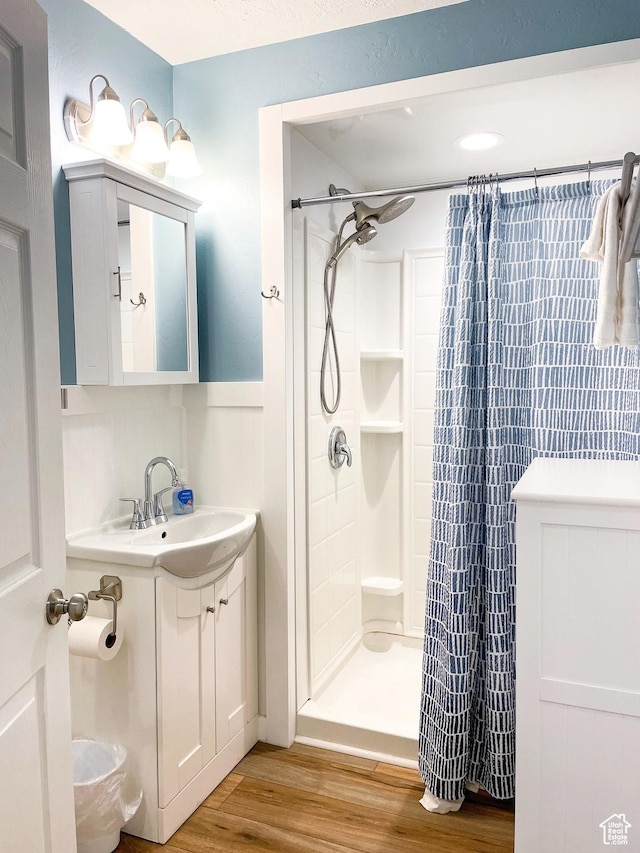 325 S 100 W, Garden City, UT 84028 - full bath featuring wood finished floors, a stall shower, wainscoting, and vanity