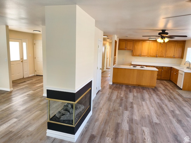 411 S Ridge Rd, Cedar City, UT 84720 - kitchen featuring light countertops, light wood finished floors, a ceiling fan, brown cabinetry, and a kitchen island