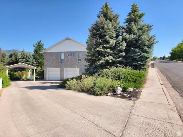 411 S Ridge Rd, Cedar City, UT 84720 - view of property exterior featuring concrete driveway, an attached garage, a carport, and a mountain view