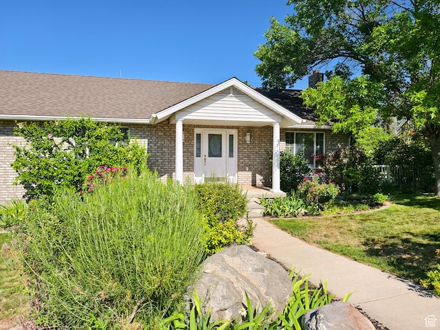 411 S Ridge Rd, Cedar City, UT 84720 - property entrance featuring brick siding, a porch, a lawn, and roof with shingles