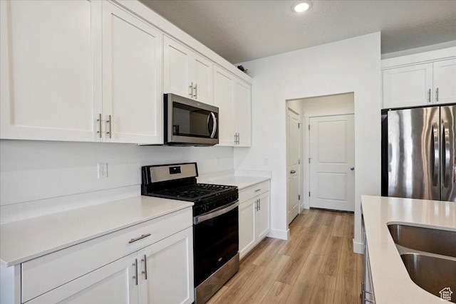 3270 N 3325 W Unit 386B, Plain City, UT 84404 - kitchen featuring appliances with stainless steel finishes, light wood-style floors, white cabinetry, light countertops, and recessed lighting